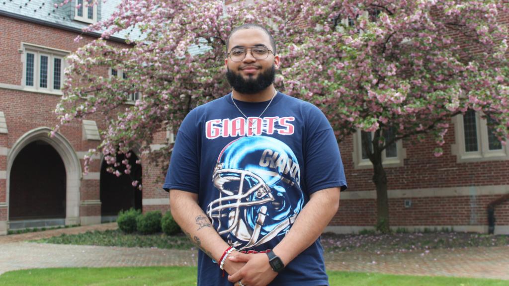 Chris Mitchell by a flowering tree in front of the Humanities Building