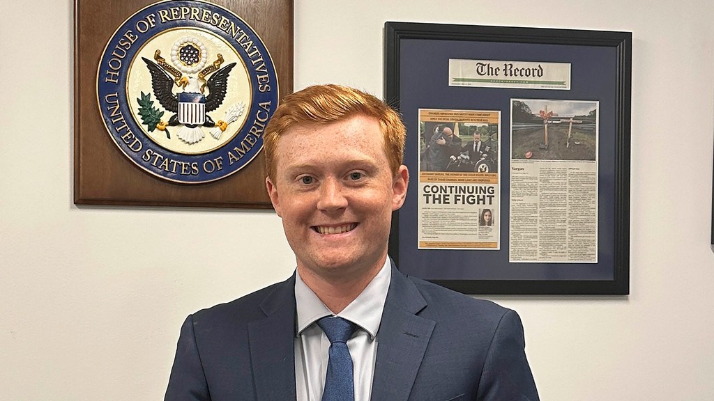 Senior Jack DeKorte standing by the U.S. House of Representatives seal