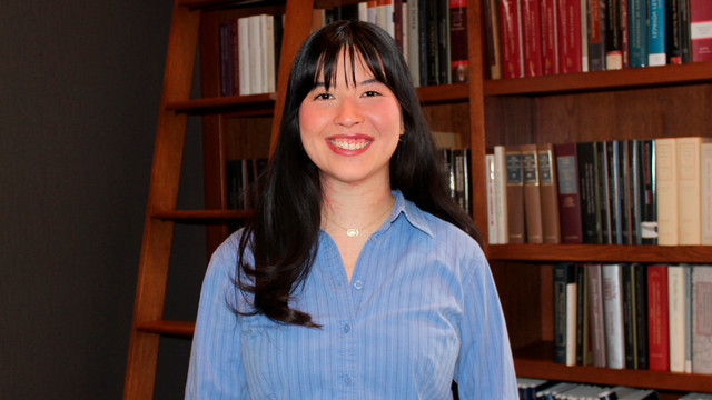 Senior Abigail Green stands by a bookcase in the Jepson Faculty Lounge
