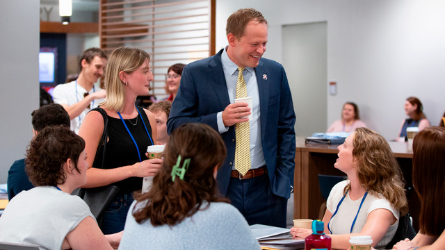 Dean of Richmond Law, Jacob Rooksby, talking with students in the Law School Commons.