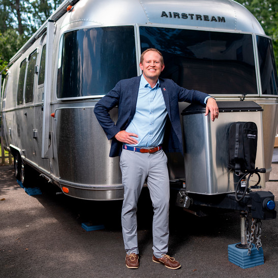 Dean of Richmond Law, Jacob Rooksby, stands next to his Airstream trailer.