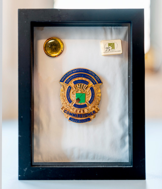 A photo of a shadowbox containing Perdue’s badge from when she served as a commissioner of the Maryland-National Capital Park and Planning Commission