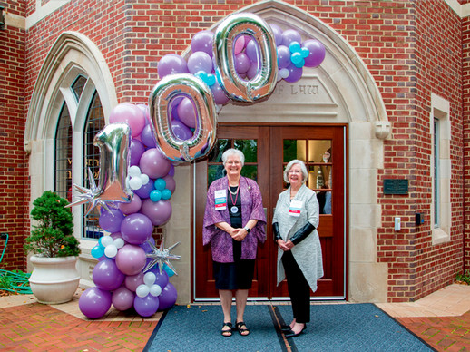 Dean Wendy Perdue and Mary Lou Kramer, L’75 in front of the Law school with a balloon arch commemorating 100 years of women at Richmond Law.