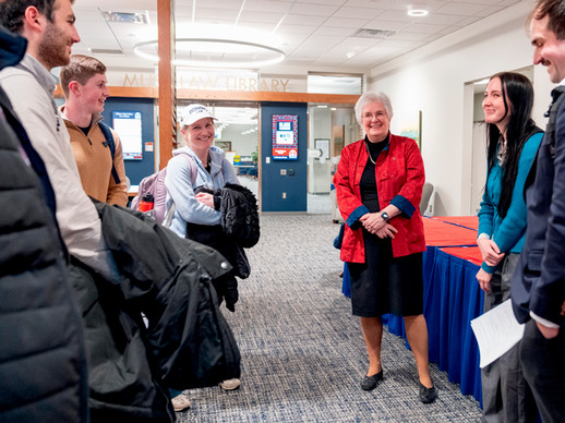Dean Wendy perdue speaking with a group of students in the law school commons.