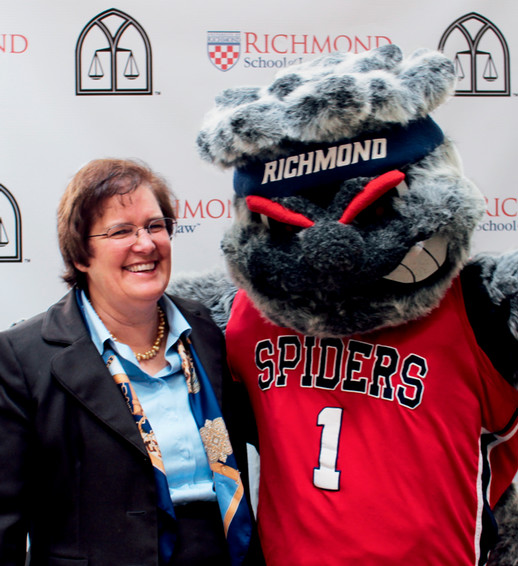 Dean Wendy Perdue and WebstUR in front of a law school logo backgdrop.