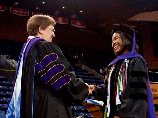 Wendy shaking hands with a student at law school commencement.