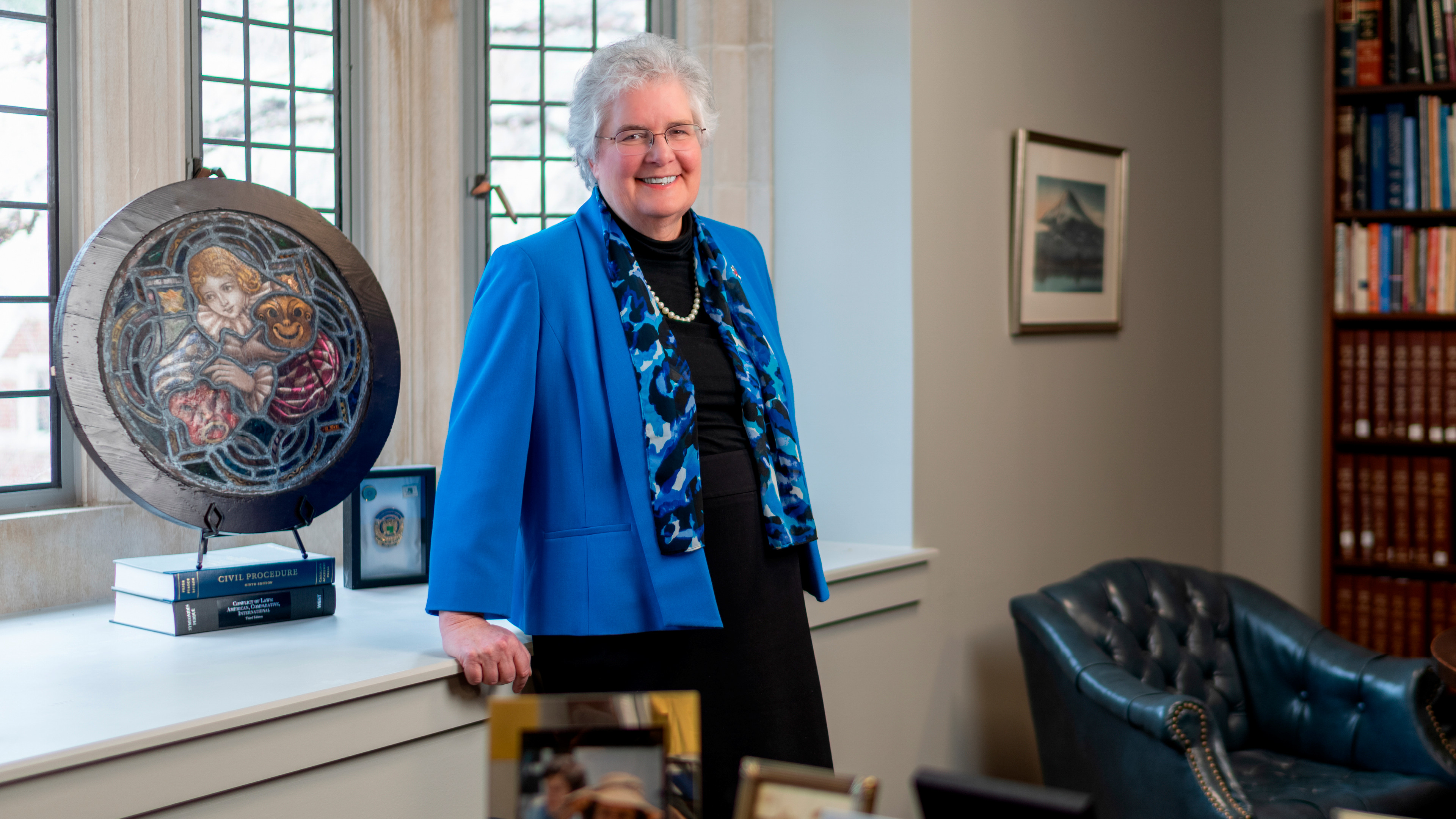 A photo of Wendy Perdue in her office. She is smiling at the camera and wearing a blue jacket.