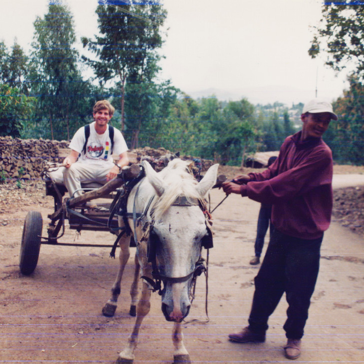 An old photo of someone riding a donkey.
