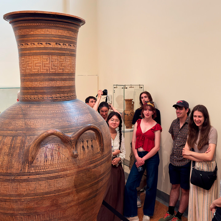Students observe a huge decorated vessel on display at the National Archeological Museum in Athens