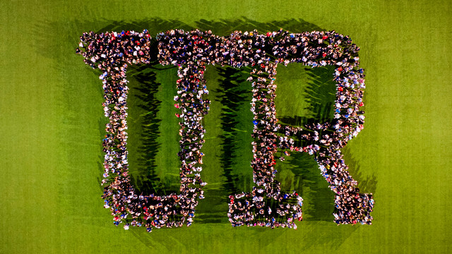 Overhead view of students forming the letters 