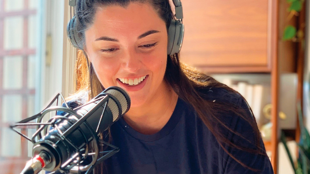 A photo of Kait Walsh, ’13, with headphones and a microphone.
