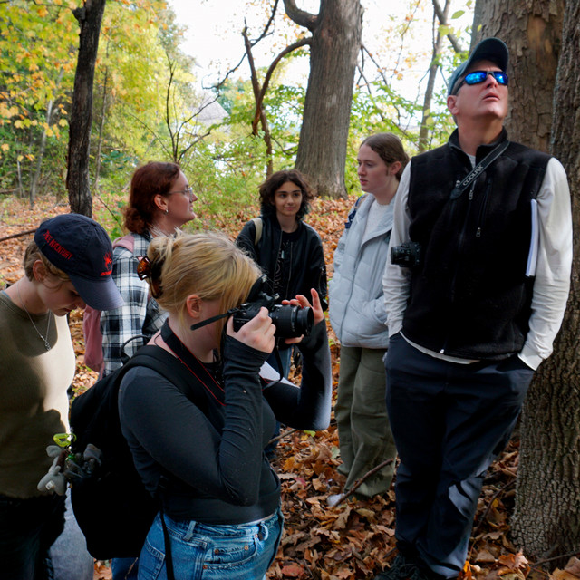 Doug Winiarski, the Richmond professor of religion and American studies, stands with students in the forest.