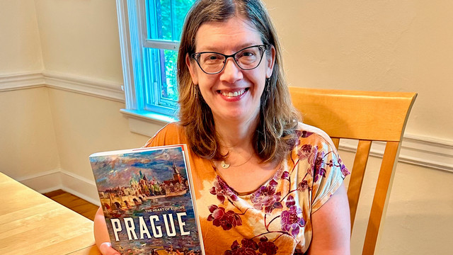 Cynthia Paces, W’92, holding her book, Prague: The Heart of Europe