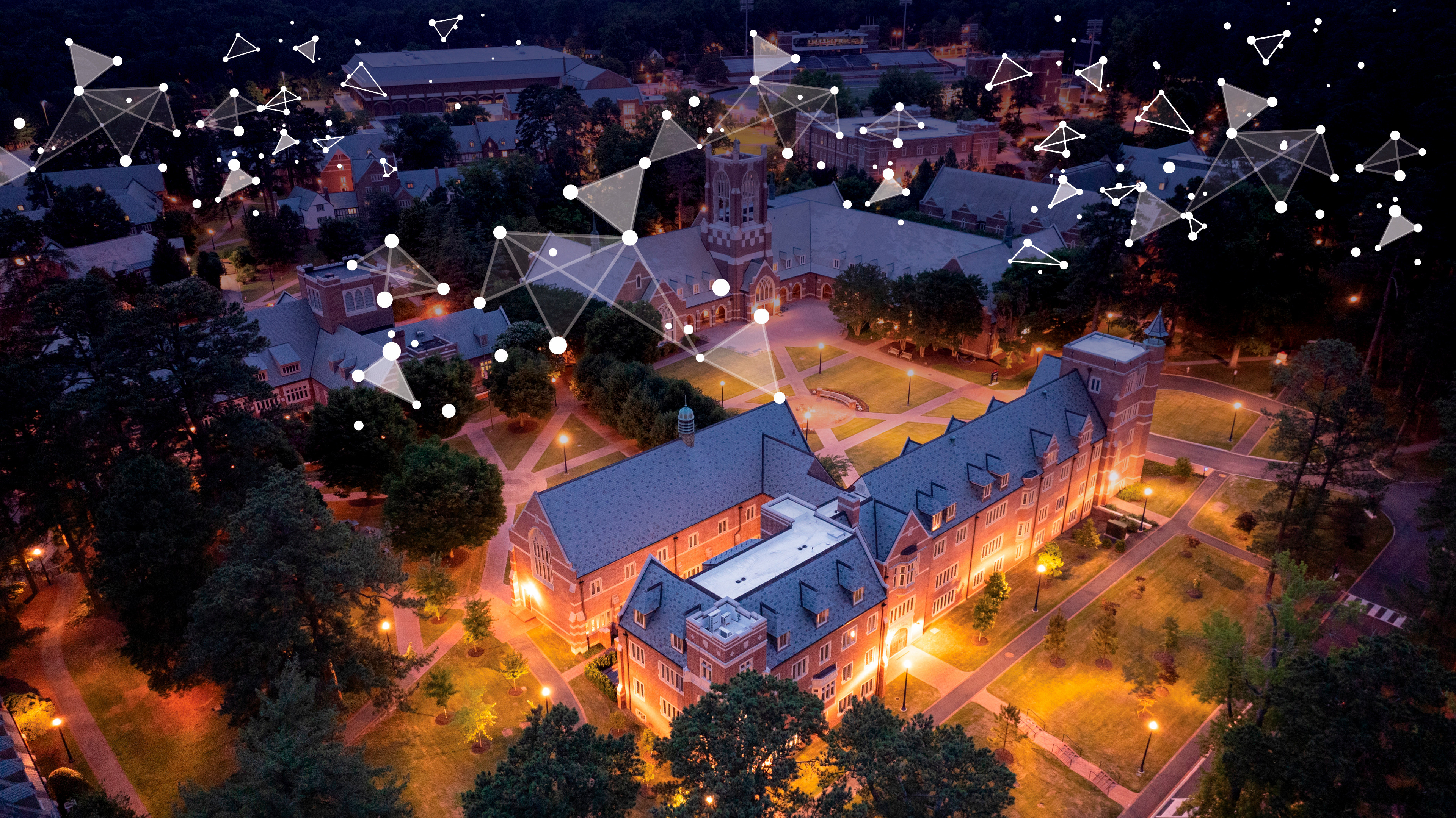 An aerial photo of the UR campus at twilight with fractal images overlaid to represent AI code
