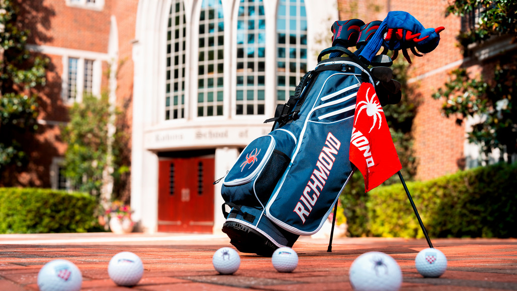 Spider golf club bag, clubs and golf balls in front of the Robins School of Business