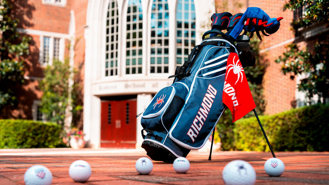 Spider golf club bag, clubs and golf balls in front of the Robins School of Business