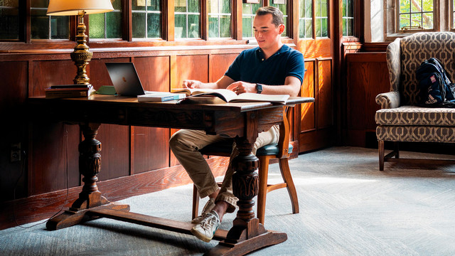 A student sits at a desk working on school work.