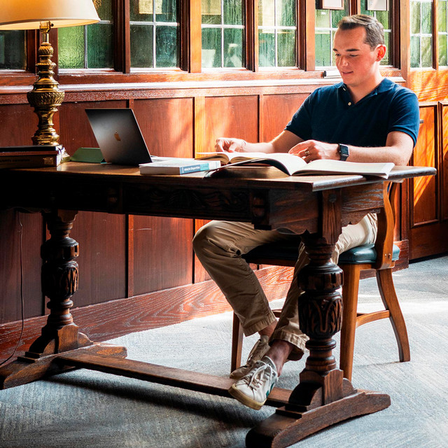 A student sits at a desk working on school work.