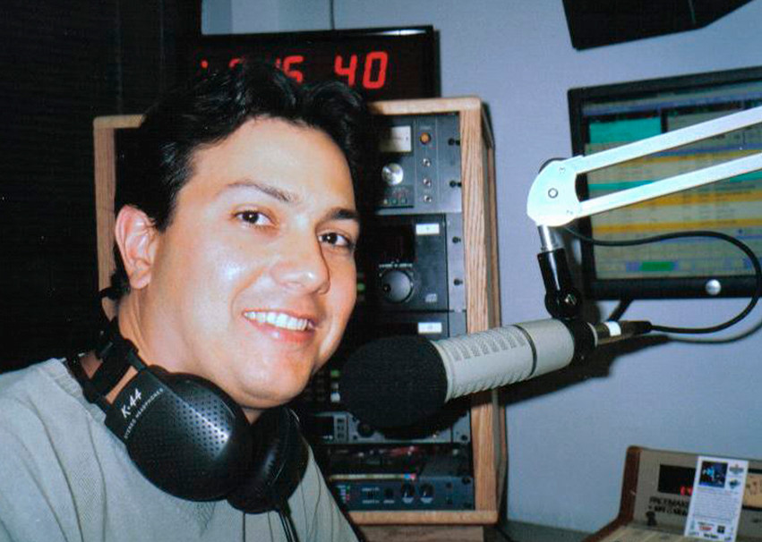 A photo of Gene de Souza with a microphone