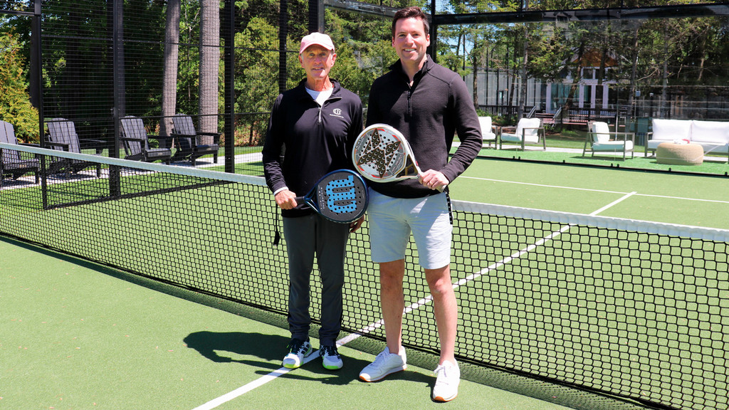 Bill Ridenour, R’79, and Gray Bigler, ’08 stand together on a padel court.
