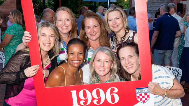 A group of women pose within a Class of 1996 frame.