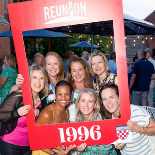 A group of women pose within a Class of 1996 frame.