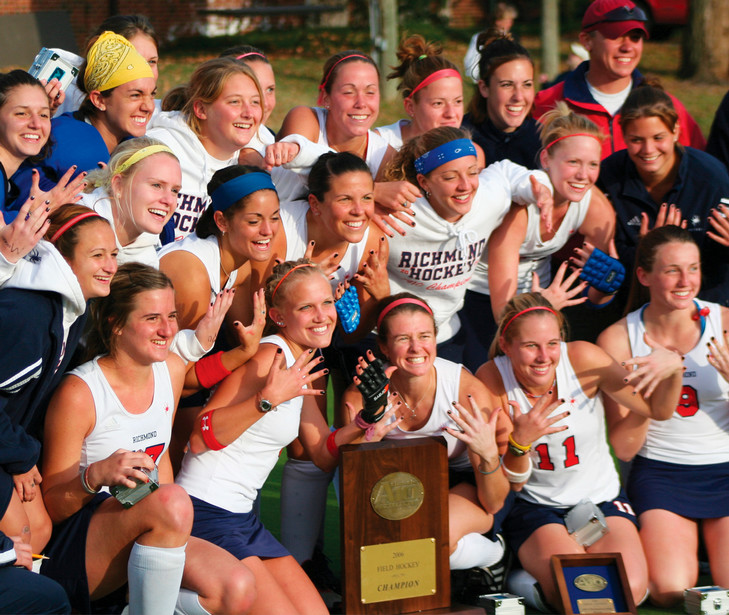 The 2006 University of Richmond field hockey team celebrating their fifth consecutive A-10 win. They are posing with the trophy and holding their hands up, showing five fingers.