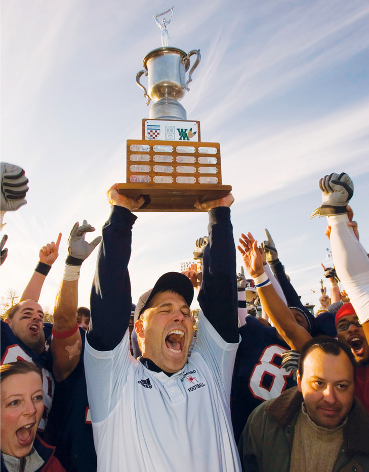 University of Richmond 2005 football coach Dave Clawson hoists the A-10 trophy in celebration.