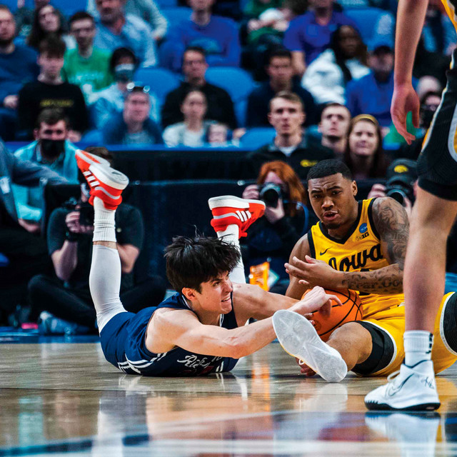 A University of Richmond men's basketball player wrestles for the ball against Iowa in the NCAA tournament.