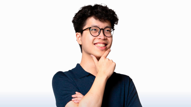 A photo of Ben Nguyen. He is smiling and holding one hand up to chin in a pose suggesting that he is thinking.