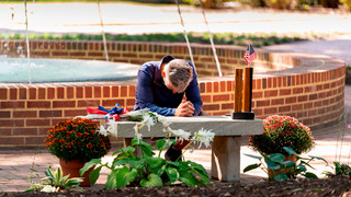 A visitor at the 9/11 memorial bench at the University of Richmond