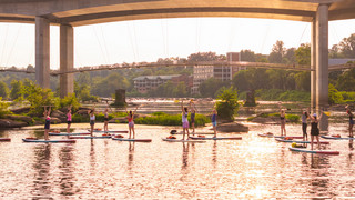 University of Richmond alumni do paddleboard yoga on the James River.