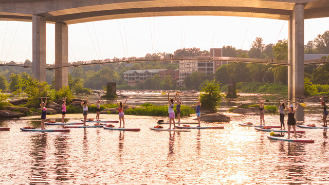 University of Richmond alumni do paddleboard yoga on the James River.