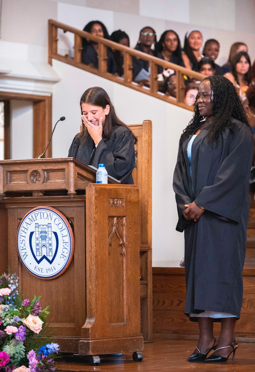Westhampton College student speaks at podium and another stands nearby