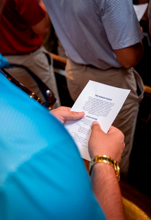 Looking over a shoulder at a copy of honor pledge in a student's hands