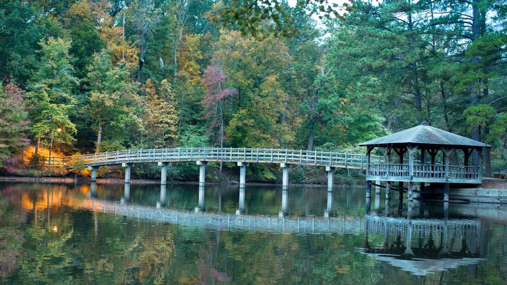Bridge to gazebo on island in a lake at dusk