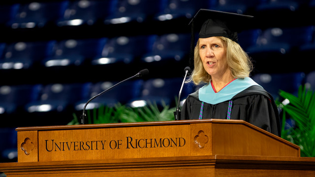 Meg Baly speaking at the University of Richmond podium during SPCS Commencement