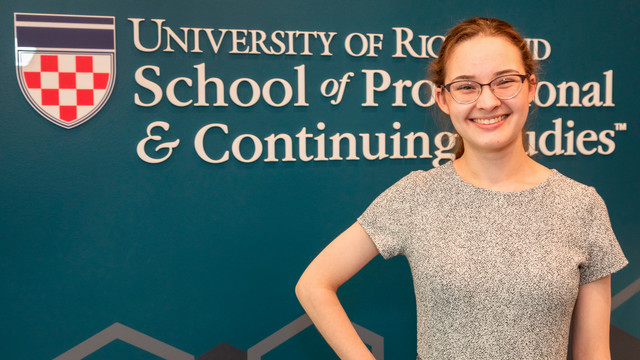 Headshot of Grace Riley in front of the SPCS logo