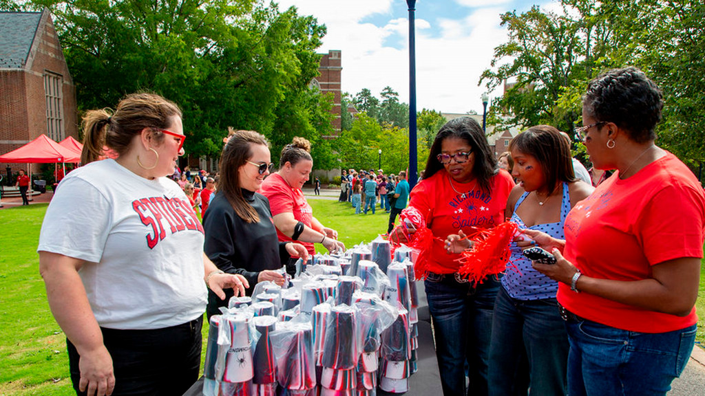 UR staff members hand out cups during Family Weekend