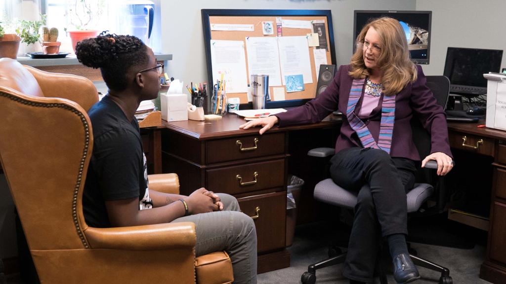 Student and faculty member having a conversation in the professor's office.