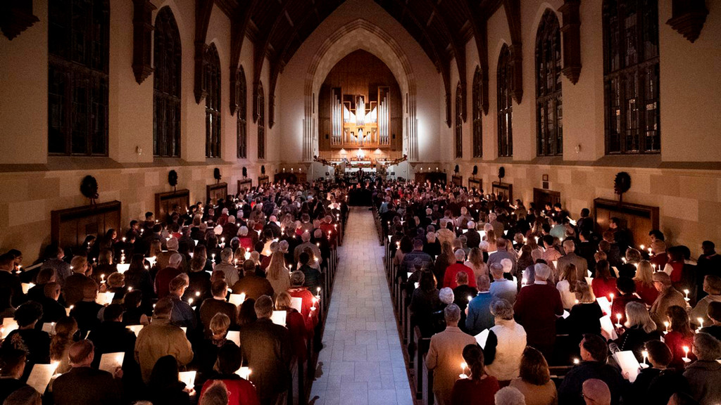 UR singers perfrom as spectators listen and hold candlelights in Cannon Memorial Chapel
