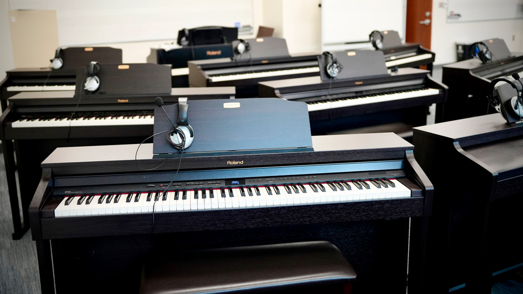 a view of several electronic pianos in the piano lab facing the front of the classroom