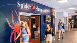 Students walk in front of the Spider Shop