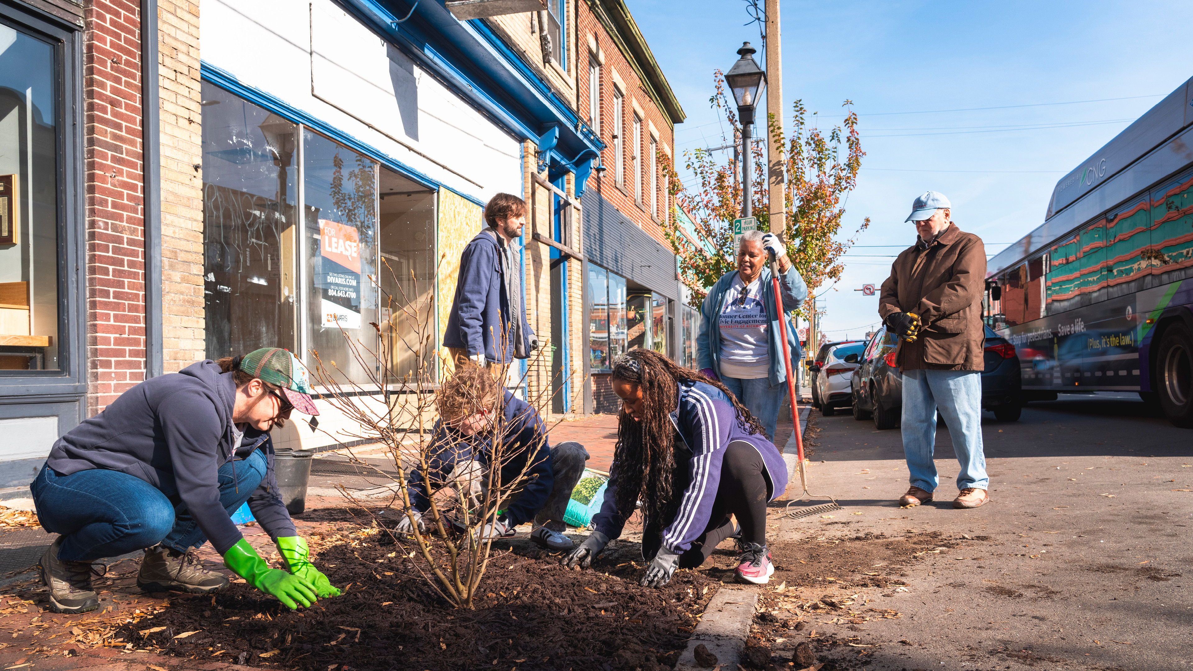 A photo of a group of University of Richmond students and faculty, as well as community volunteers, planting trees in the Jackson Ward neighborhood in Richmond, VA.