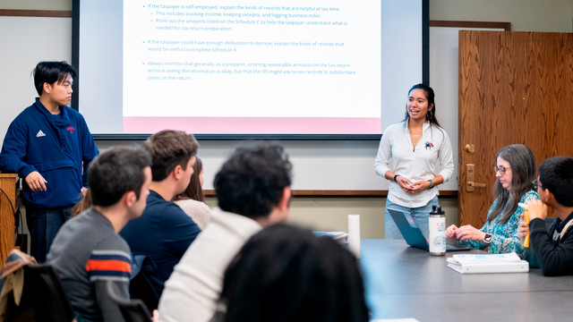 A photo of students Jolie Martin and Zheke Qian, both accounting majors, conducting a volunteer tax workshop.