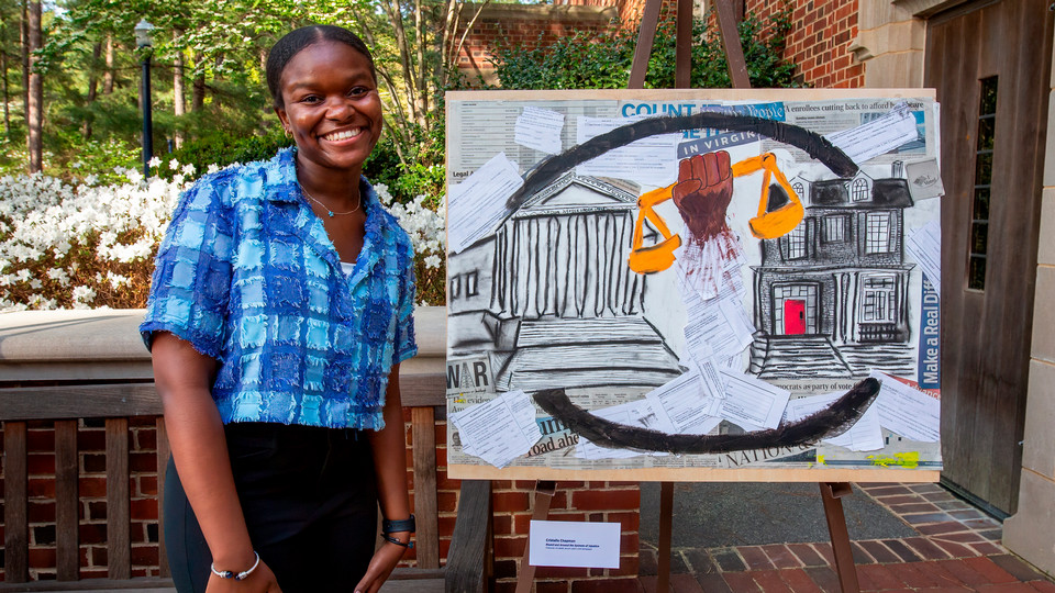 A photo of Bonner Scholar Cristall Chapman posing with a painting she created as part of her work with Hamilton Glass