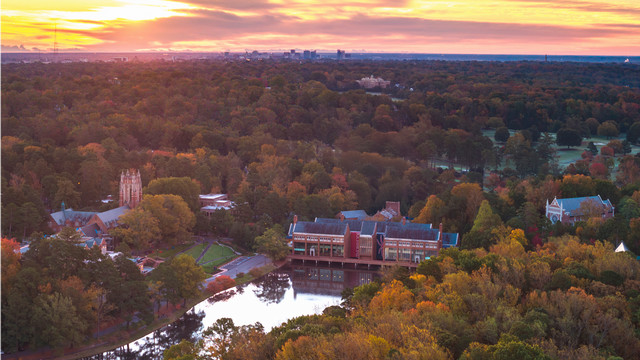 An aerial photo of the University of Richmond campus in the fall, with the city of Richmond visible in the distance.
