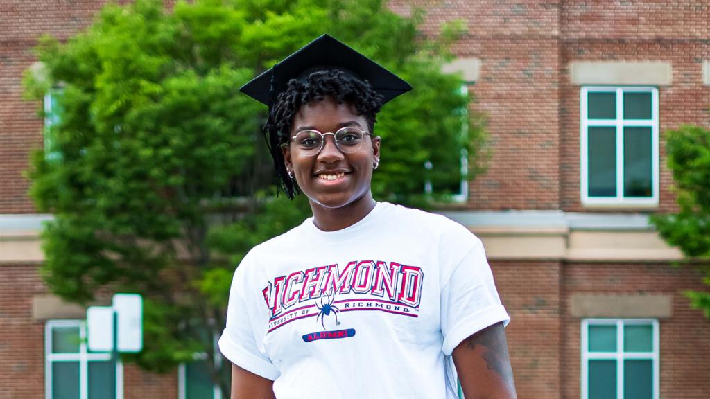 Jaide posing in their graduation cap and Richmond t-shirt.
