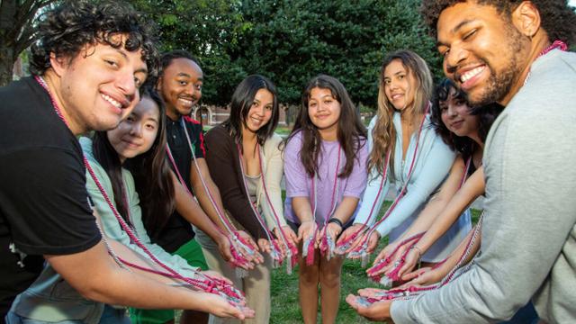 Students posing with graduation cords