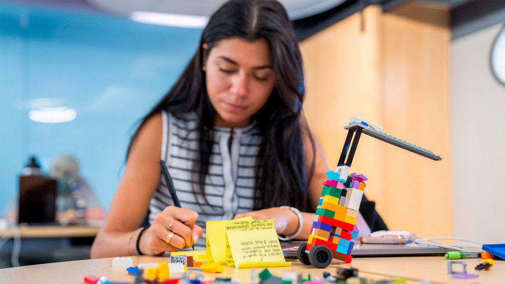 Student brainstorming with post-it notes and Lego Serious Play